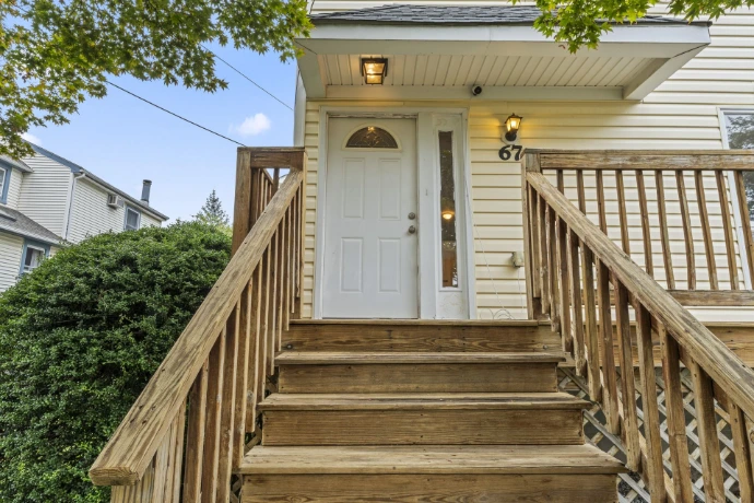 Residential property in Springfield, NJ, with wooden entrance steps, railings and a covered front doorway.
