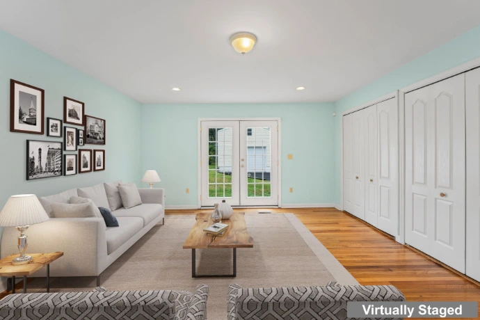 Virtually staged residential living space with digitally added sofa, rug, coffee table and decorative furnishings.