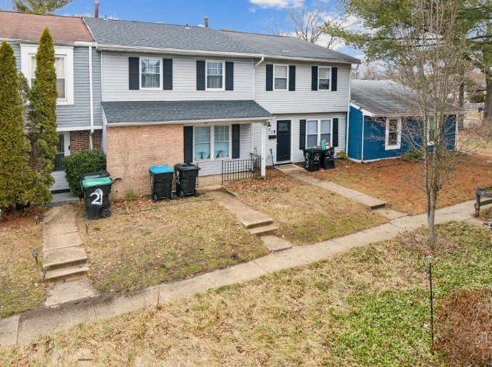 Real estate photography in Camden County, NJ, showing a two-story residential property with traditional siding, a brick-fronted entrance and surrounding grounds.