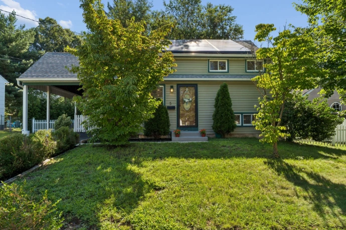Real estate photography in Hunterdon County, NJ, showing a stone-fronted suburban home with landscaped gardens, a curved walkway and driveway.