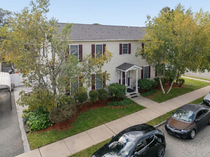 Real estate photography in Bergen County, NJ, featuring a traditional detached home with a covered porch, front lawn and mature trees.